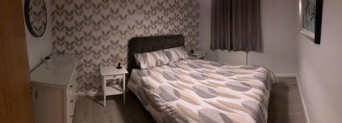a bedroom with a bed and a nightstand with a bed sidx sidx sidx sidx at Chapel Court Apartments in Cannock