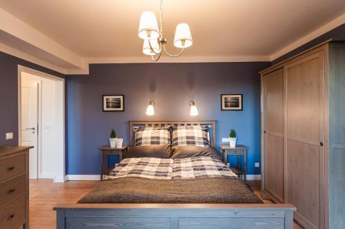 a bedroom with blue walls and a large bed at Haus am See B&B in Bornheim