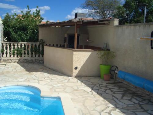 una casa con piscina accanto a una recinzione di Villa avec jardin à Poussan avec piscine privée ouverte toute l'année a Poussan