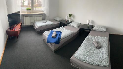 a room with three beds and a desk at Hostel Czecha in Warsaw
