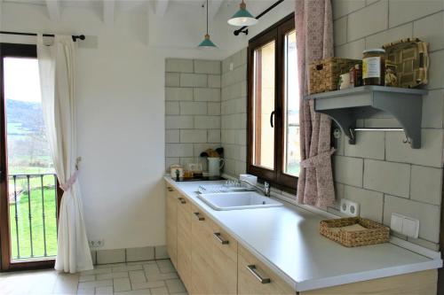 a kitchen with a sink and a window at El Mirador de Casa Guareña in Villabáscones de Sotoscueva