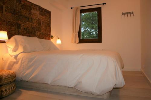 a bedroom with a white bed with a window at El Mirador de Casa Guareña in Villabáscones de Sotoscueva