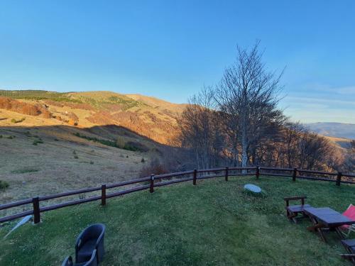 a picnic table and benches on a hill with a fence at Vila Dizdarevic Kopaonik in Kopaonik
