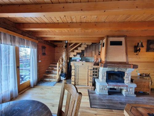 a living room with a fireplace in a log cabin at Vila Dizdarevic Kopaonik in Kopaonik