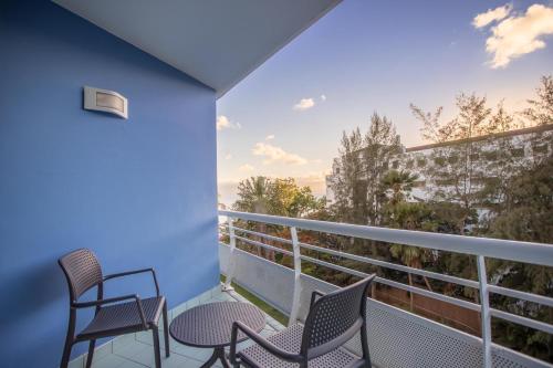 a balcony with chairs and a view of the ocean at Zenitude Hôtel Résidences Le Salako in Le Gosier