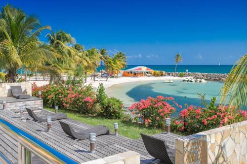 a view of a beach with chairs and the ocean at Zenitude Hôtel Résidences Le Salako in Le Gosier