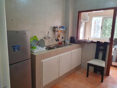 a small kitchen with a sink and a refrigerator at Appart Sly Abidjan in Cocody