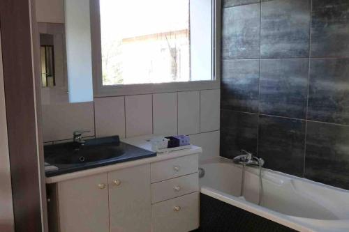 une salle de bain avec un lavabo et une baignoire dans l'établissement Villa entre lac et océan, à Biscarrosse