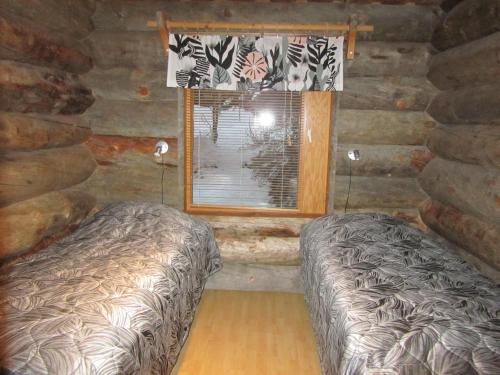 a bedroom with a bed and a window at Rukakaiku Cottages in Ruka