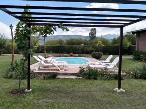 薩爾塔的住宿－El Indalo La Calderilla，一组白色椅子和一个游泳池