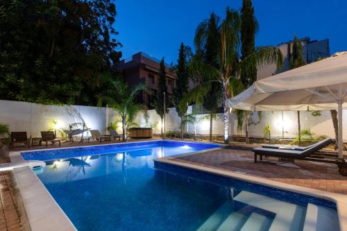 a swimming pool with an umbrella next to a building at Villa 56 Luxury apartments in Rhodes Town