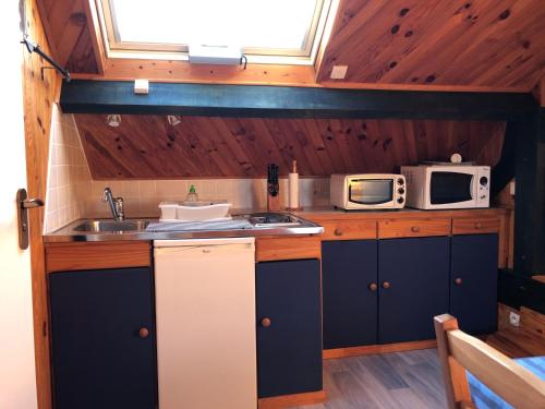 La cuisine est équipée d'un évier et de 2 micro-ondes. dans l'établissement Appartement F1 mansardé à 100m de la plage, proche de Arromanches et des plages du Débarquement, à Saint-Côme-de-Fresné
