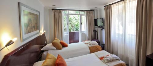um quarto de hotel com duas camas e uma janela em Termas El Corazon em San Esteban