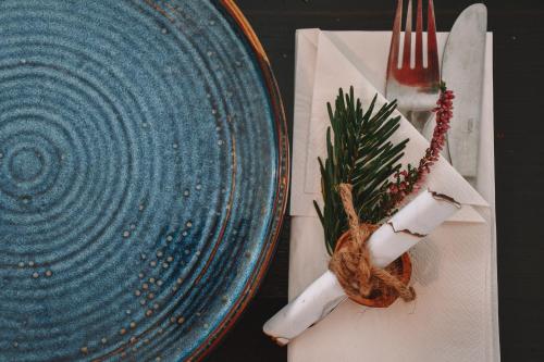 a blue plate on a table with a knife and fork at Boutique Hotel Pinzgauerhof in Kaprun
