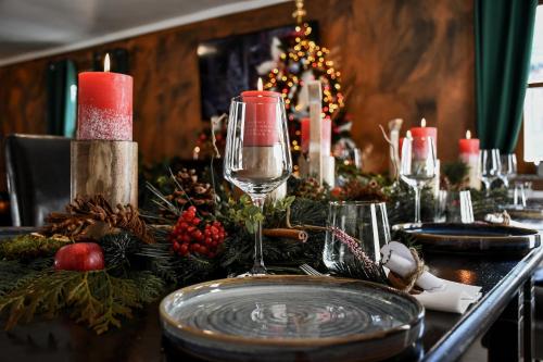 a christmas table with a candle and wine glasses at Boutique Hotel Pinzgauerhof in Kaprun