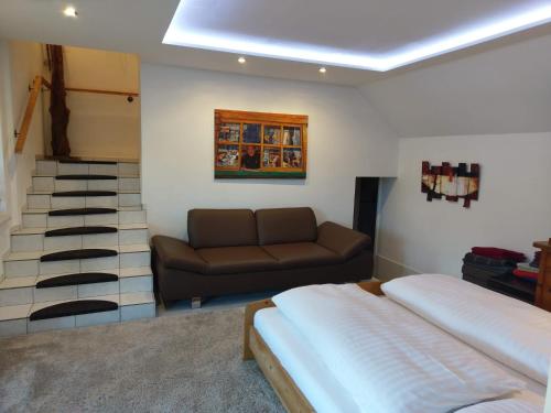 Pokój z łóżkiem, kanapą i schodami w obiekcie Apartment Erlauf - Ursprung, - 6 Personen, Outdoorsauna mit Bachzugang w mieście Mitterbach