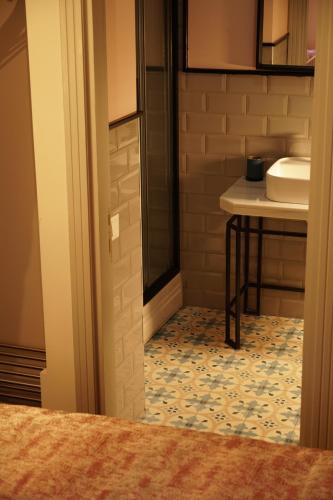 a bathroom with a sink and a toilet and a table at Tilas - Rooms in 19th Century Wooden Townhouse,Kadikoy in Istanbul