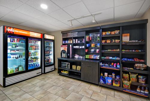 a grocery store aisle with refrigerators and shelves of food at Candlewood Suites Sumter by IHG in Sumter