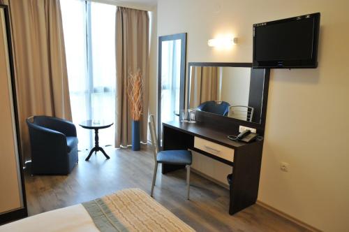 a hotel room with a desk and a mirror at Hotel Burgas Free University in Burgas