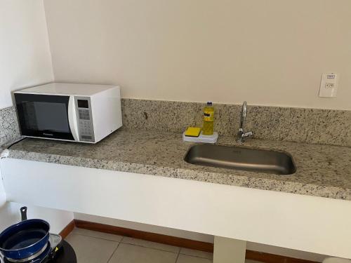 Una encimera de cocina con un microondas y un fregadero. en Flat à beira mar em João Pessoa -Pacific Flat, en João Pessoa