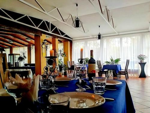 a table with a blue table cloth and a bottle of wine at Котедж-парк Славна in Okhtyrka