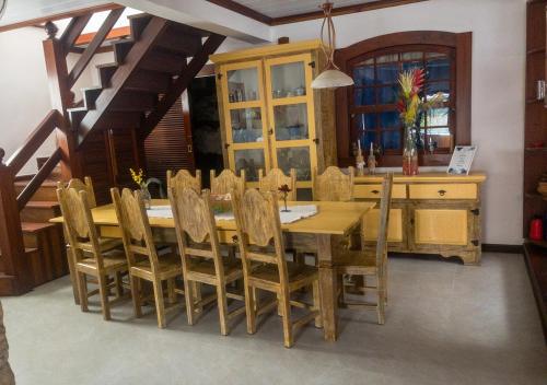 una sala da pranzo con tavolo e sedie in legno di Casarão Paraty a Parati