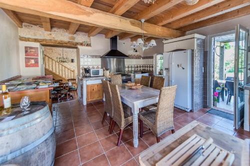 une cuisine et une salle à manger avec une table et des chaises dans l'établissement Domaine des clauzes, à Fauch