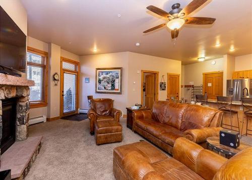 a living room with leather furniture and a fireplace at Expedition Station by Summit County Mountain Retreats in Keystone