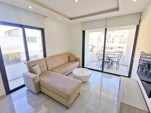 a living room with a couch and a table at Vasilo Court Seaview City Apartment in Larnaca
