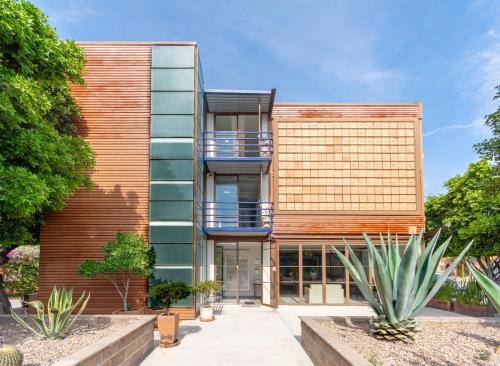 un edificio de apartamentos con fachada de madera y algunas plantas en Kubo Hotel, en San Miguel de Allende