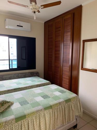ein Schlafzimmer mit einem Bett und einem großen Fenster in der Unterkunft Capitania Varam in Guarujá