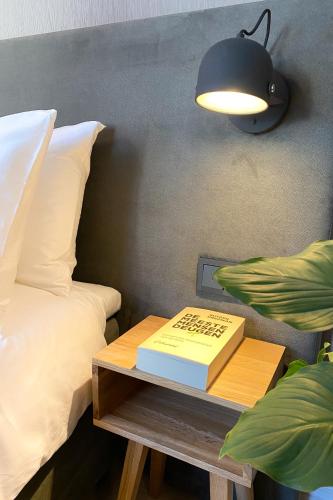 a book on a table next to a bed at Hotel Flora Batava in Breukelen