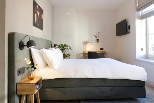 a bedroom with a large bed and a table at Hotel Flora Batava in Breukelen
