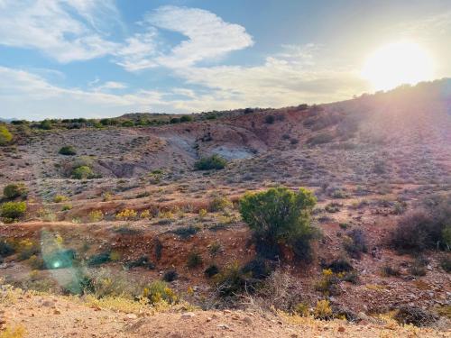 a view of the desert with the sun setting on a hill at Die Kliphuisie in Oudtshoorn