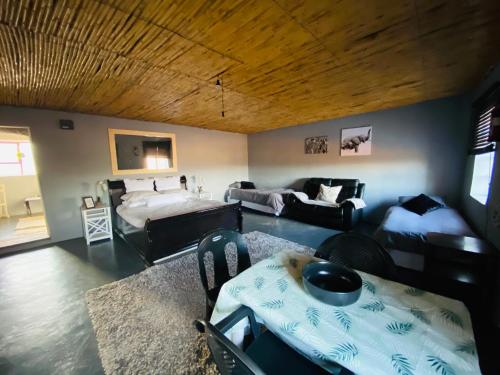 a living room with a bed and a couch at Die Kliphuisie in Oudtshoorn