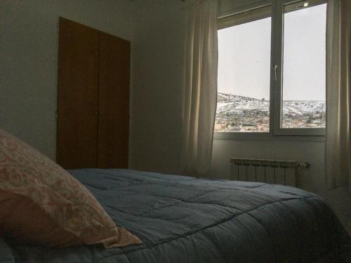 コモドーロ・リバダビアにあるCactuSのベッドと景色の見える窓のある寝室