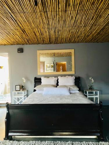 a bedroom with a large bed with a wooden ceiling at Die Kliphuisie in Hoopvol