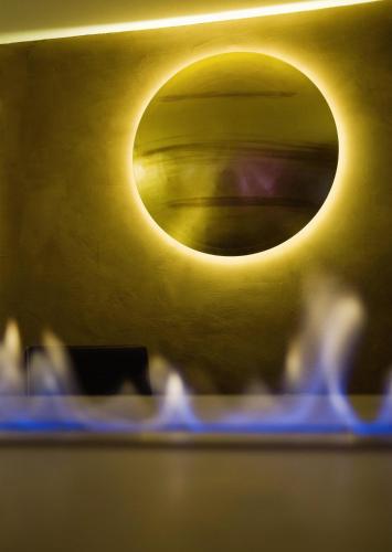 a yellow wall with a round light on it at Hotel Restaurant Spa Torkel in Nonnenhorn