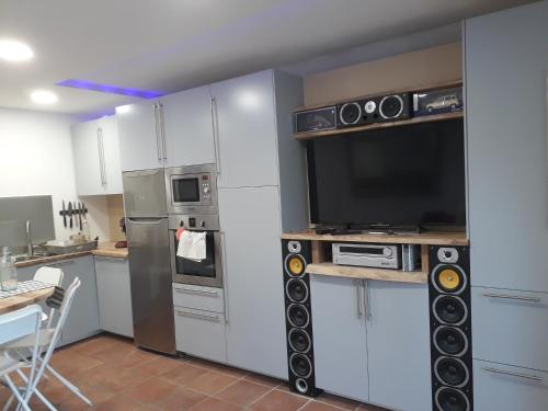 une cuisine avec des armoires blanches et une télévision à écran plat dans l'établissement Appartement Seignosse Océan, à Seignosse