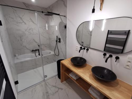 a bathroom with a sink and a shower and a mirror at The Penthouse, oasis of light and inspiration in Antwerp