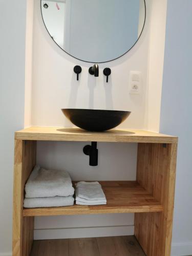 a bathroom with a sink and a mirror on a shelf at The Penthouse, oasis of light and inspiration in Antwerp
