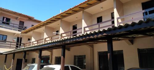 a large building with cars parked in front of it at Pousada Minas Gerais in Tramandaí