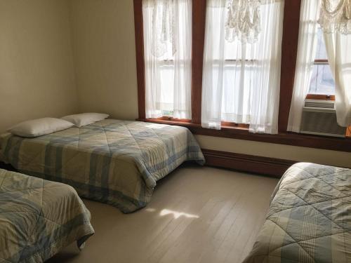 a bedroom with two beds and two windows at Aunt Jane's Two in Put-in-Bay