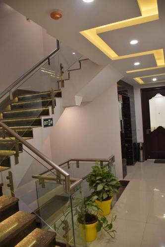 a lobby with stairs and potted plants at Lemon Green Residency - Hotel and Serviced Apartments in New Delhi