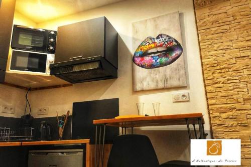 - une cuisine avec une table et un four micro-ondes dans l'établissement L'Authentique - Le Poirier, à Orléans