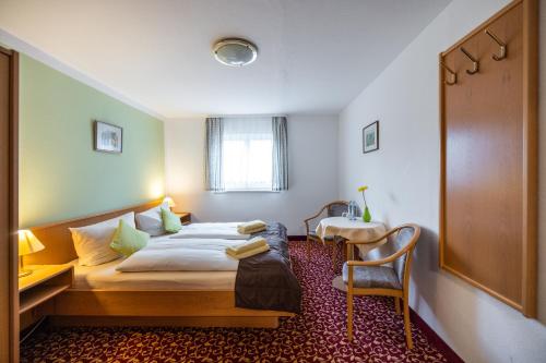 a hotel room with a bed and a desk at Pension & Café Abendröte in Kurort Oybin
