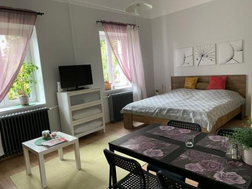 1 dormitorio con 1 cama y 1 mesa con sillas en Négy évszak Apartman- Tapolca, en Tapolca