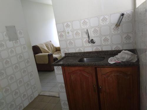eine Küche mit einem Waschbecken und ein Wohnzimmer in der Unterkunft Mar Azul Condomínio in Aracaju