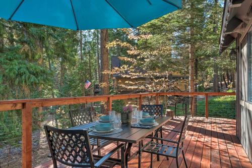 a table and chairs on a deck with an umbrella at Family Cabin in Blue Lake Springs, Near Town! in Arnold