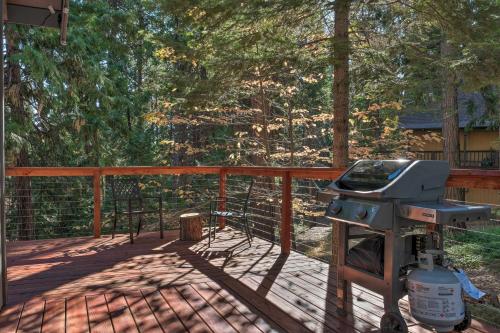 a grill on a deck with a fence and trees at Family Cabin in Blue Lake Springs, Near Town! in Arnold